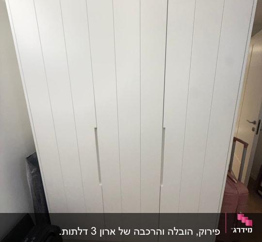 ארון לבן עם מזוודות מסביבו בחדר